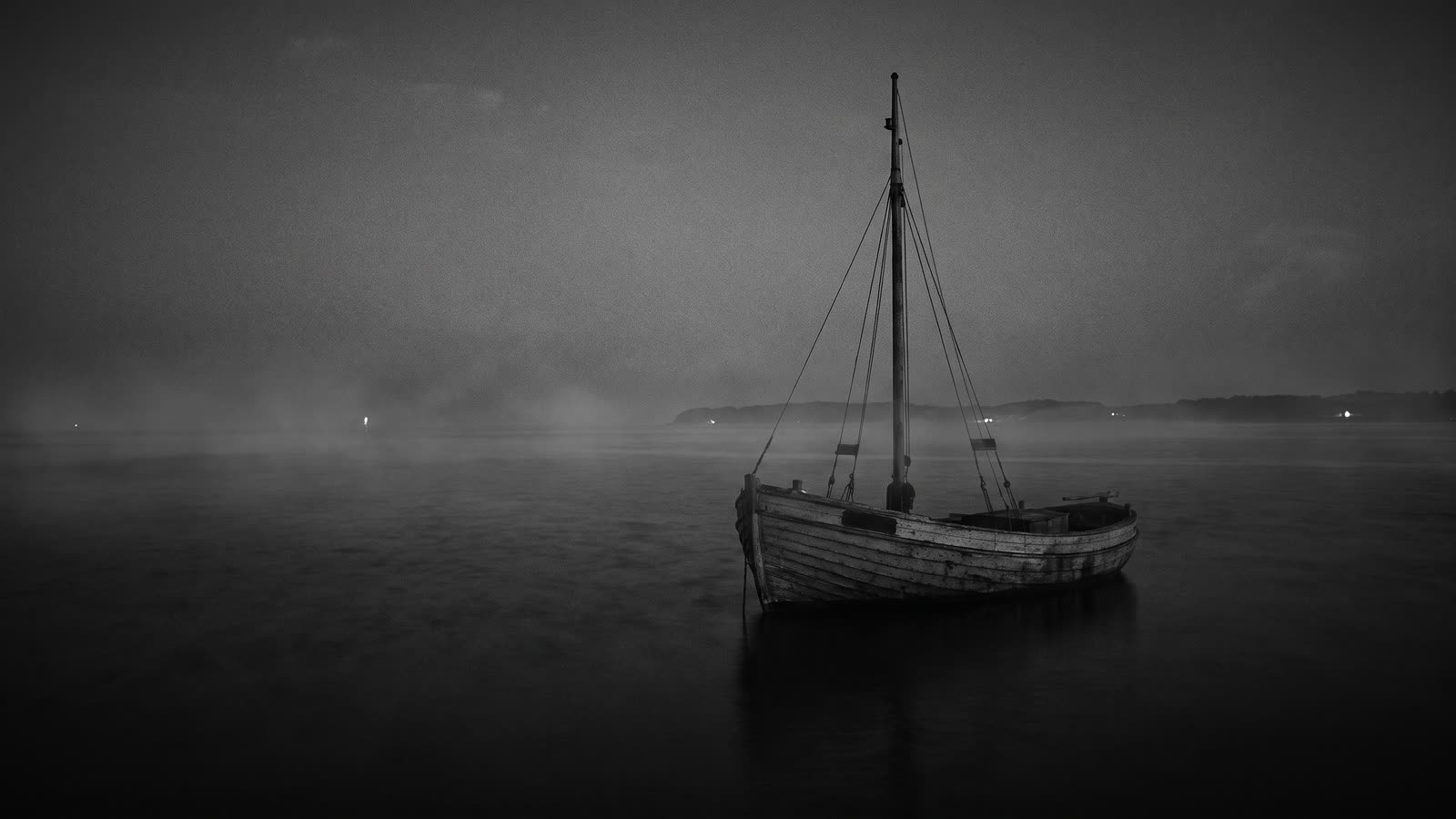 En lille fiskerbåd på mørkt, stille vand om natten